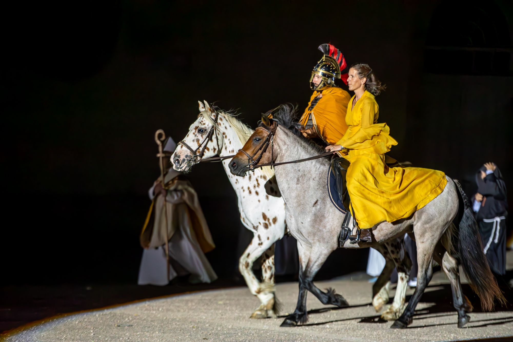 Un cavalier romain et une dame en robe jaune à cheval, dans la nuit, pendant Murmures de la Cité